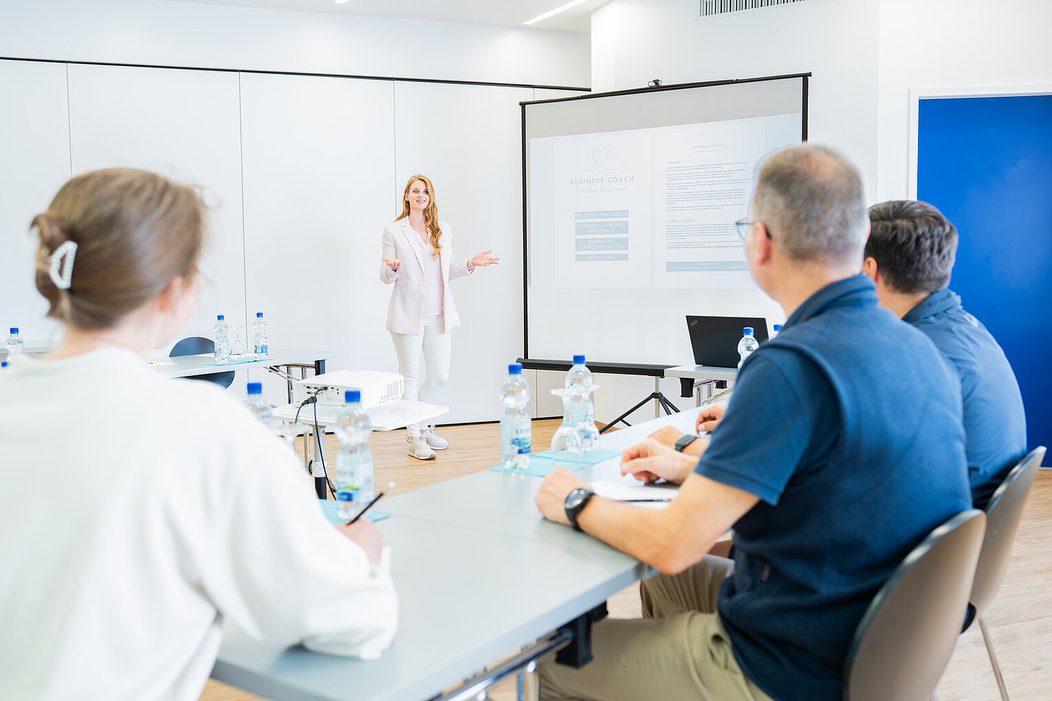 Alexandra Schattmaier hält ein Business Coaching für Führungskräfte in einem modernen Seminarraum.